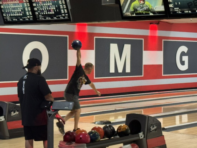 Bowler in full backswing releasing a blue ball